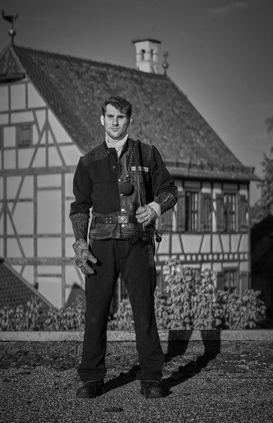 Schornsteinfeger vor einem Fachwerkhaus, Schwarzweißfoto